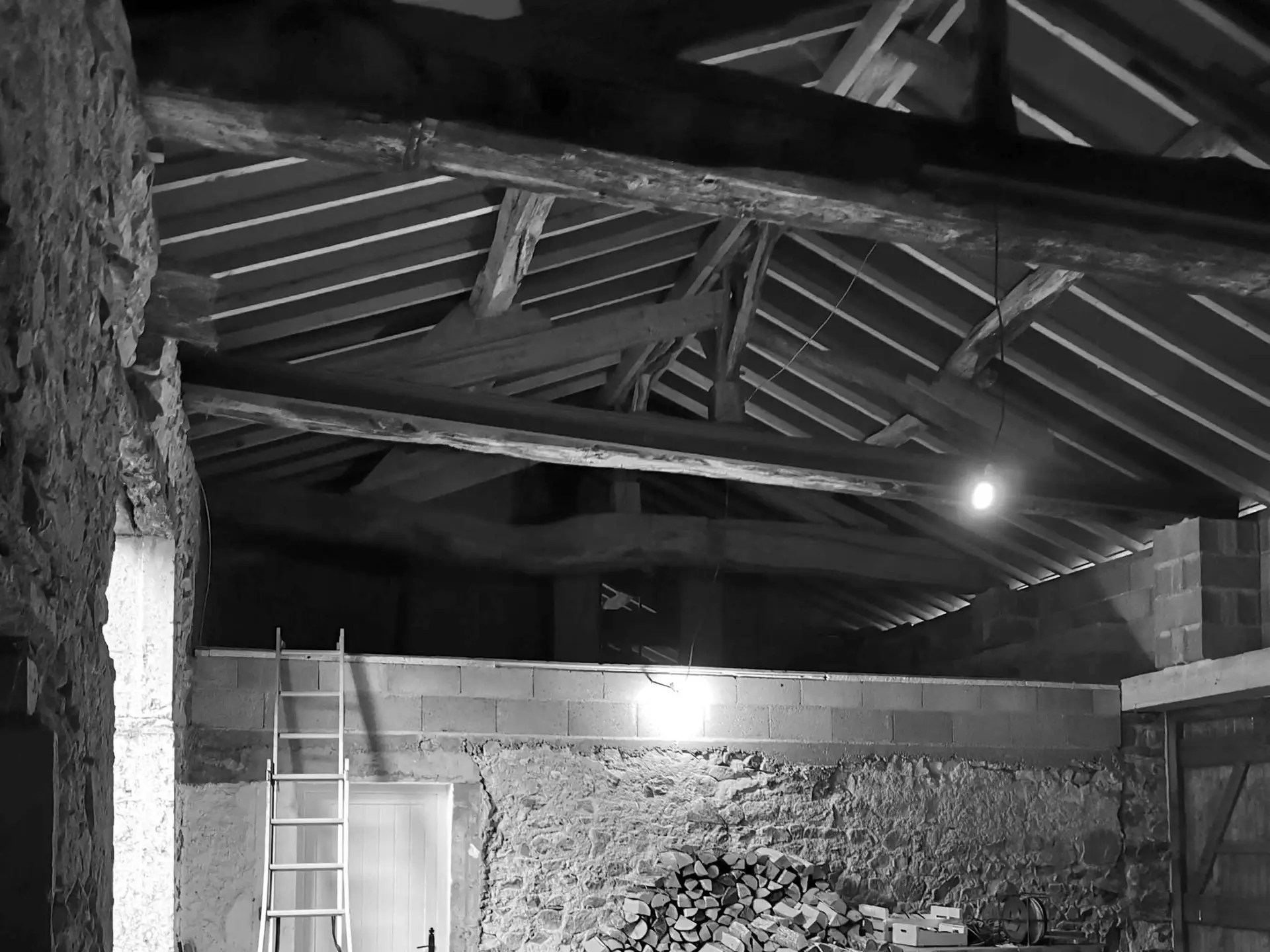 Photographie en noir et blanc d'une grange à rénover dans le Clunysois : vue de l'intérieur.