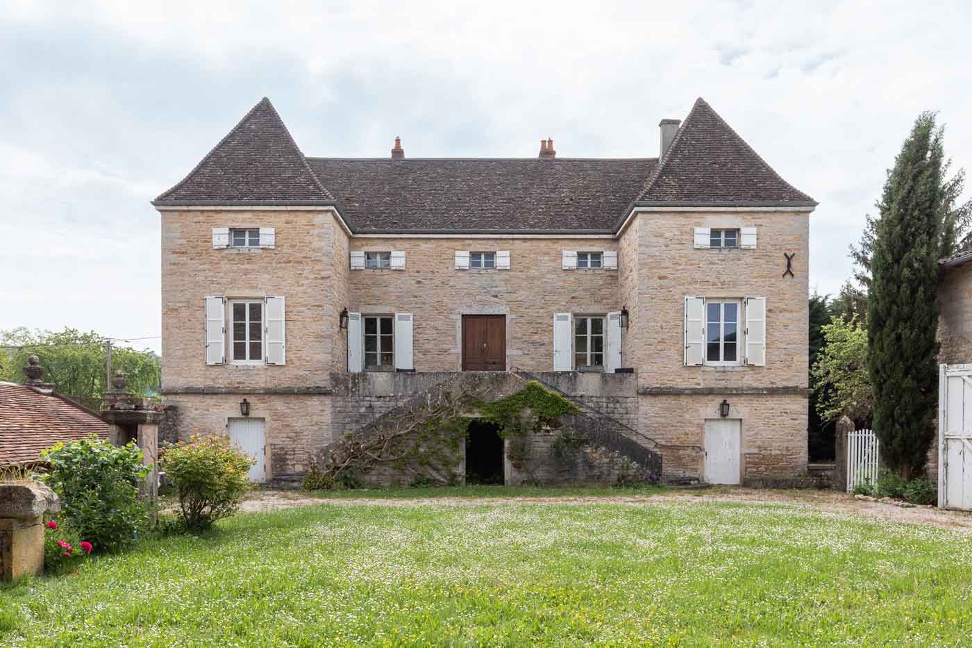 Photographie d'une maison en pierre avec deux tours symétriques.